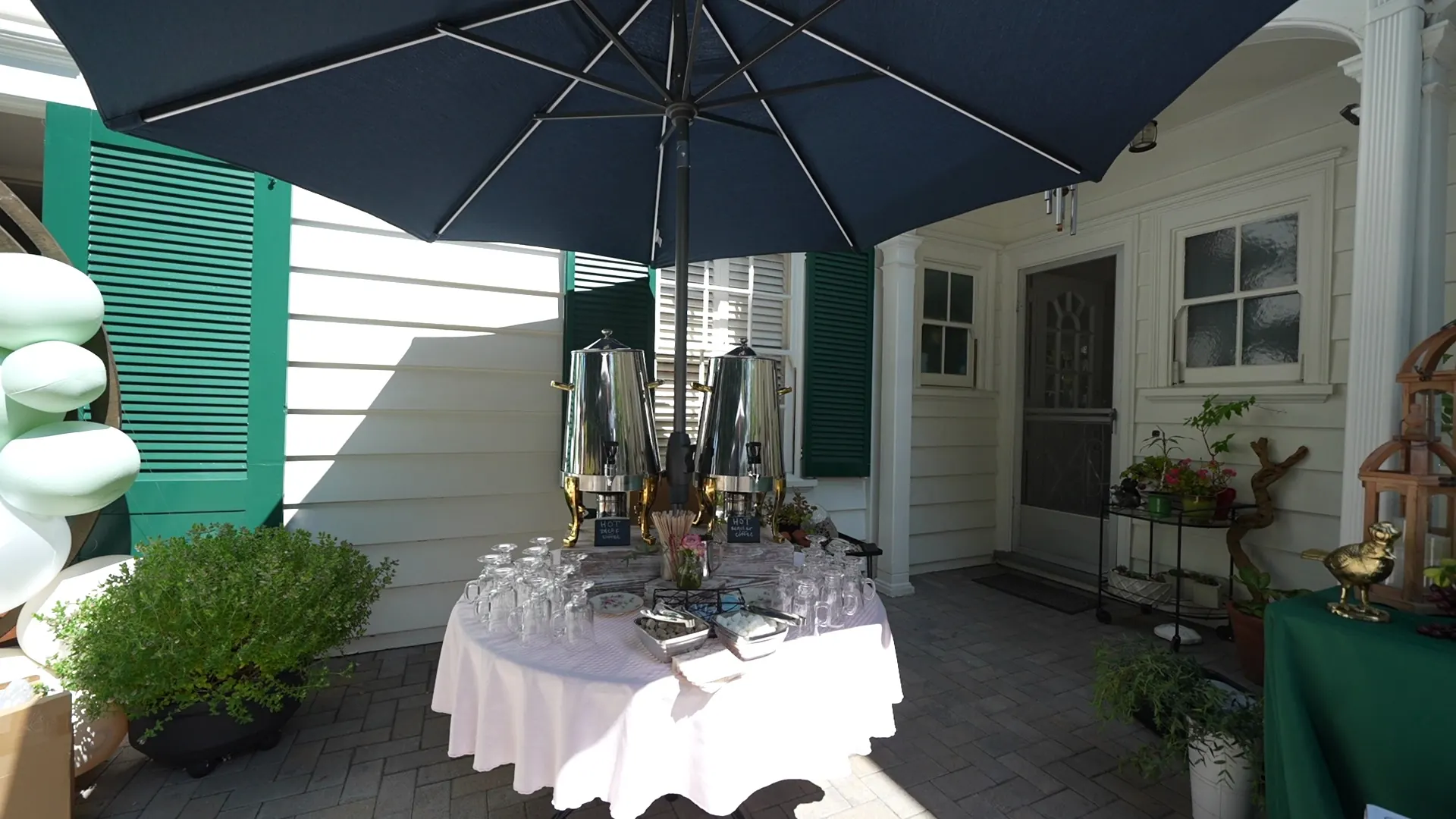 Beverage station shaded by an umbrella at a Millbrae backyard event