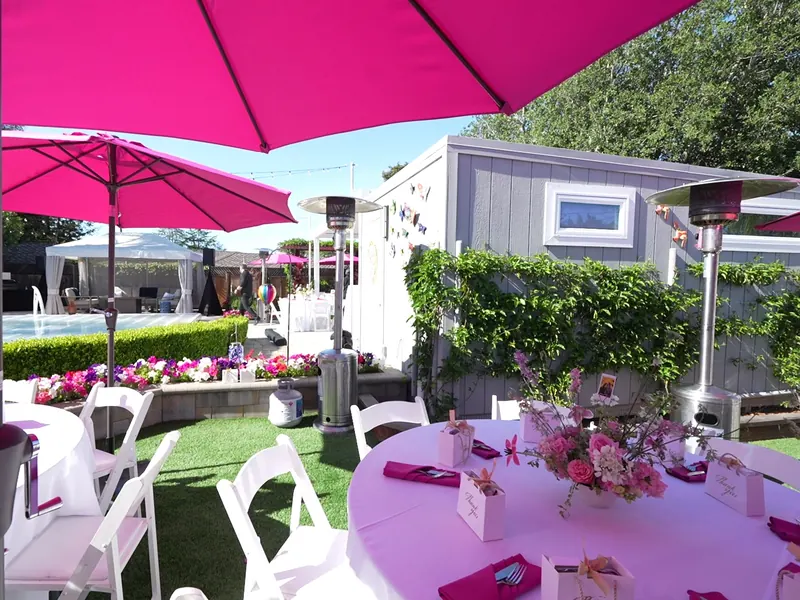 Umbrella-shaded patio tables set for a catered lunch in San Mateo