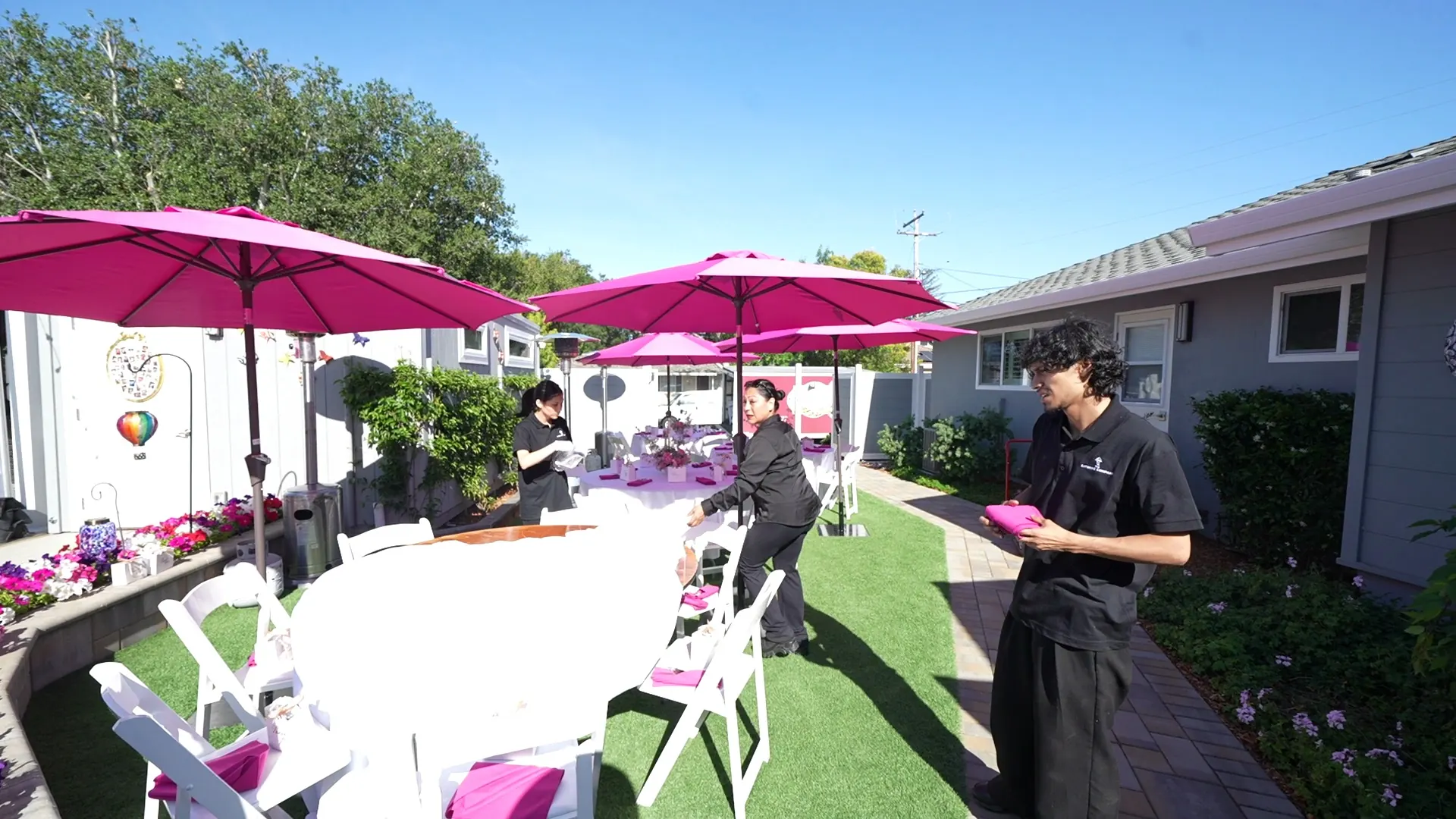 Attendant tending a shaded patio buffet at a San Bruno party