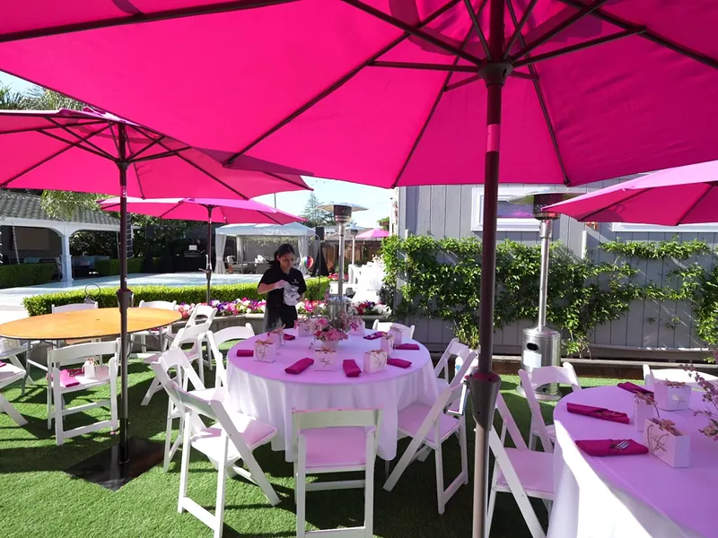 Lawn tables under bright umbrellas at a San Mateo afternoon gathering