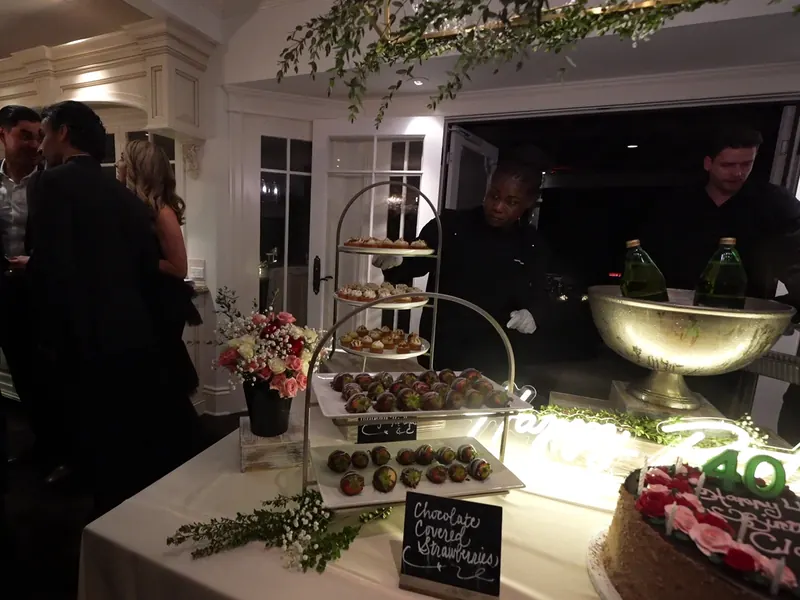 Server passing desserts from a tiered display at a Belmont celebration