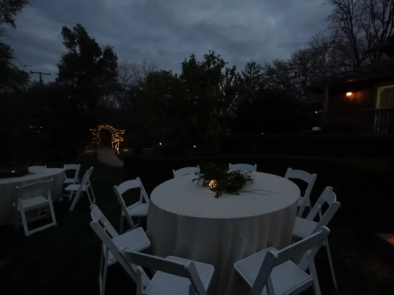 Round table set at twilight for a Hillsborough garden dinner