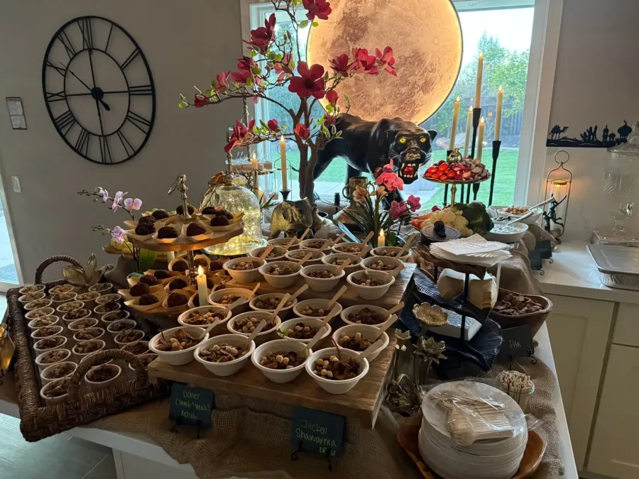 Mediterranean buffet of shawarma chicken, kebob and mezze framed by low seasonal arrangements — buffet florals for Pacifica catering dinners